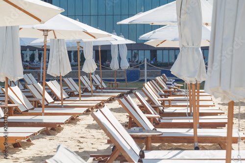 Empty beach chairs and umbrellas on sea shore. Not a season
