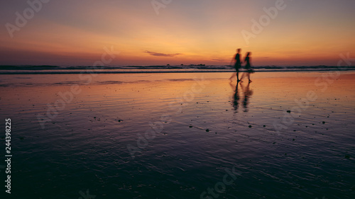 two people walking on beach © david