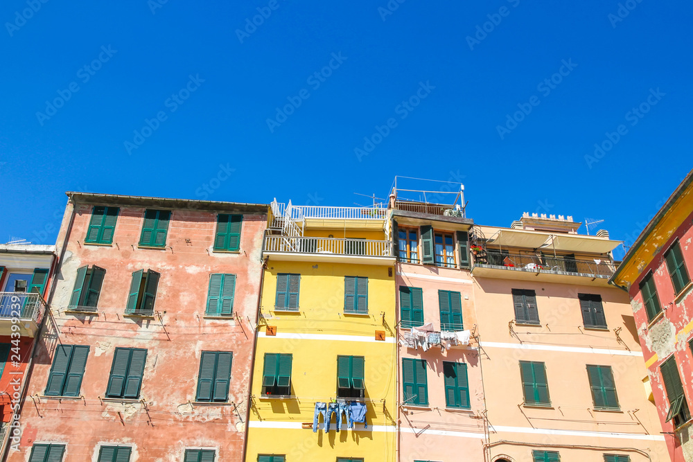 View on the beautiful colourful houses with clothes drying in the sunny daylight in Cique Terre, Italy.