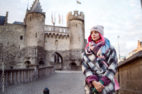 Young sexy girl with pink hair and beautiful face in coat near Antwerp castle