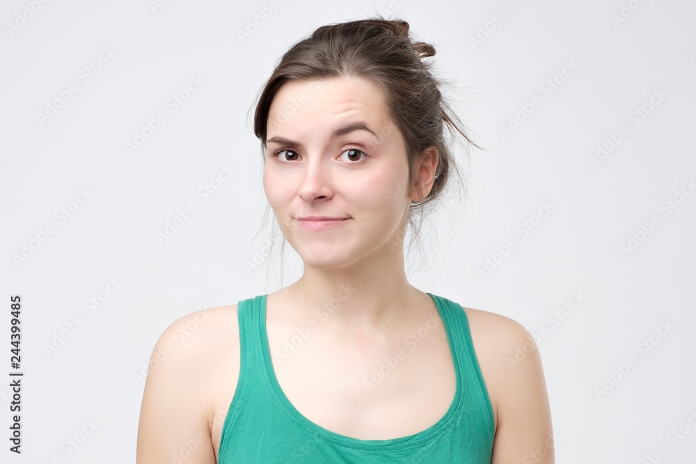 Doubting woman being disappointed or unimpressed over gray wall. Doubting woman being disappointed or unimpressed over gray wall.