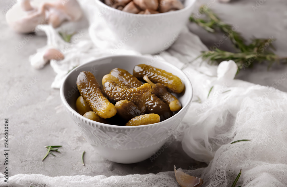 Fototapeta premium Bowl with tasty fermented cucumbers on grey table