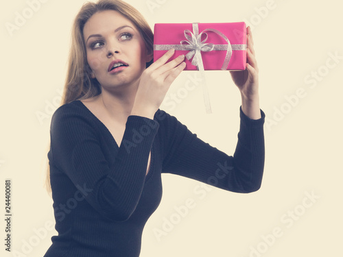 Girl holding present shaking pink gift box © anetlanda