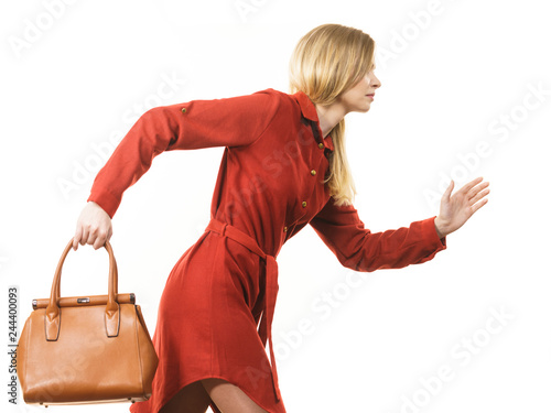 Female wearing red dress holding bag running