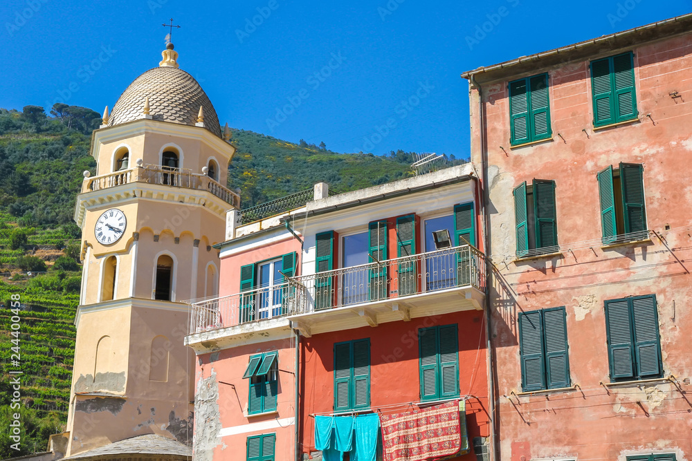 View over the the medieval clock tower of Cinque Terre, Italy with colourful houses on a sunny day.