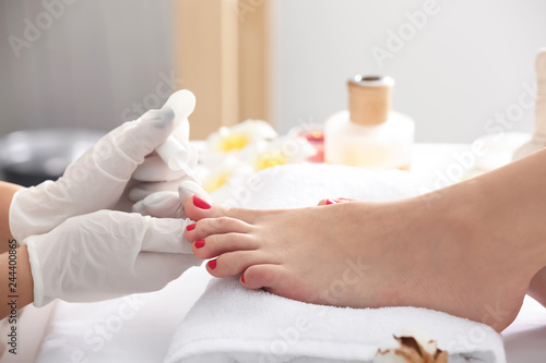 Young woman getting pedicure in beauty salon