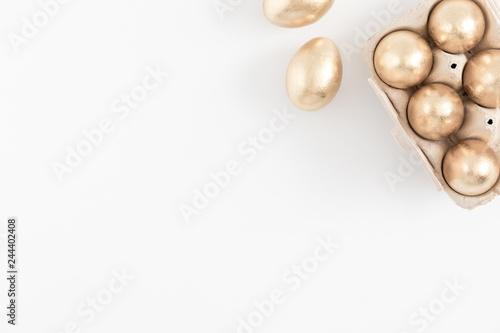 Easter golden eggs, easter decorations on white background. Flat lay, top view, copy space 