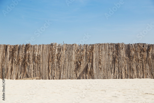 Palm leaves fence in the sand