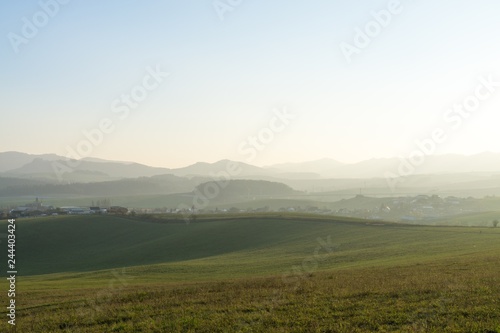 Misty morning on meadow with trees and views. Slovakia