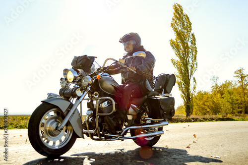Motorcycle Driver Riding Custom Chopper Bike on Autumn highway. Adventure Concept.