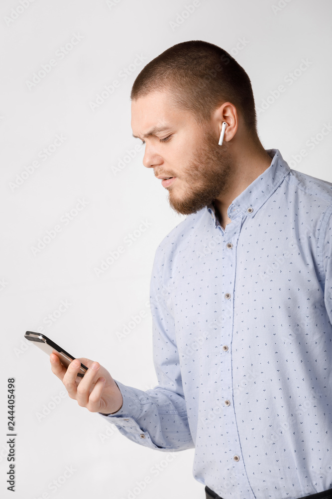bearded businessman uses wireless headphones and smartphone bearded businessman uses wireless headphones and smartphone