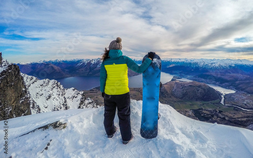 Winter sport activity.Woman holding snowboard, overlooking mountain landscape freedom, enjoying a winter, cold season. Having fun on the snow, mountains, ski area, Remarkables, New Zealand, Queenstown photo