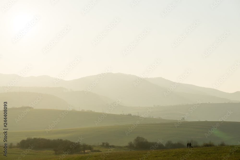 People walking on a meadow during sunset. Slovakia	