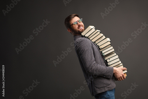 Fotografie, Obraz Young student carrying stack of books
