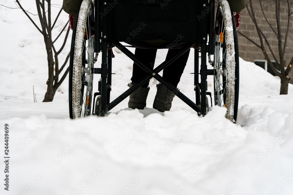 Disabled handicapped man has a hope. He sits in a wheelchair and looks at a mountain of snow. The complexity of the movement of the disabled. On a wheelchair in the winter. Disabled handicapped man has a hope. He sits in a wheelchair and looks at a mountain of snow. The complexity of the movement of the disabled. On a wheelchair in the winter.