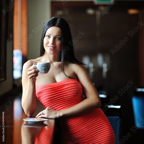 Young woman sitting in a restairant with a cup of coffee
