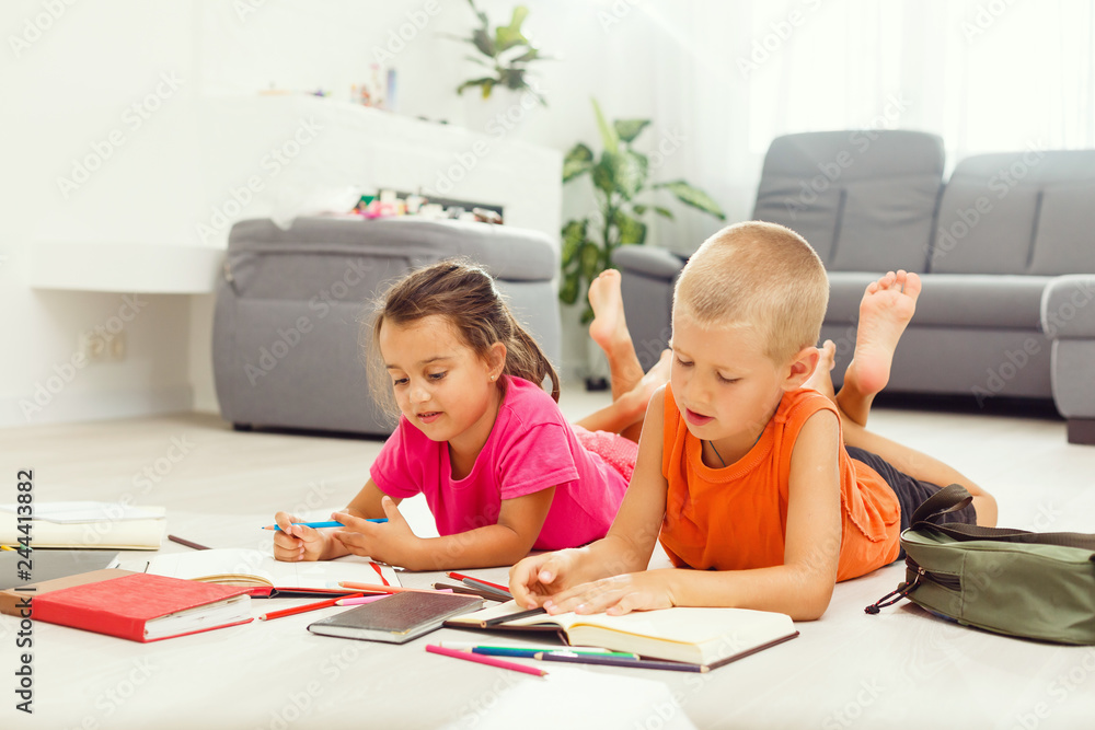 Two cute children draws on floor at home Two cute children draws on floor at home