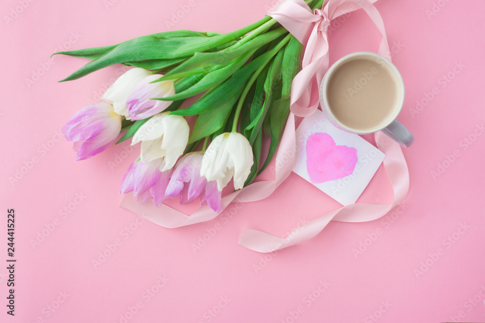 Bouquet of tulips and a coffee cup on a pink pastel background. Wonderful spring breakfast on Mother's Day or Women. Flat lay. View top. Selective focus. Bouquet of tulips and a coffee cup on a pink pastel background. Wonderful spring breakfast on Mother's Day or Women. Flat lay. View top. Selective focus.