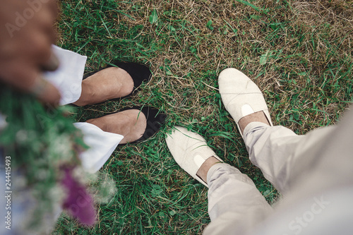 Top view of stylish hipster couple legs in shoes. Happy family couple relaxing in evening summer city. Vacation  and travel together photo