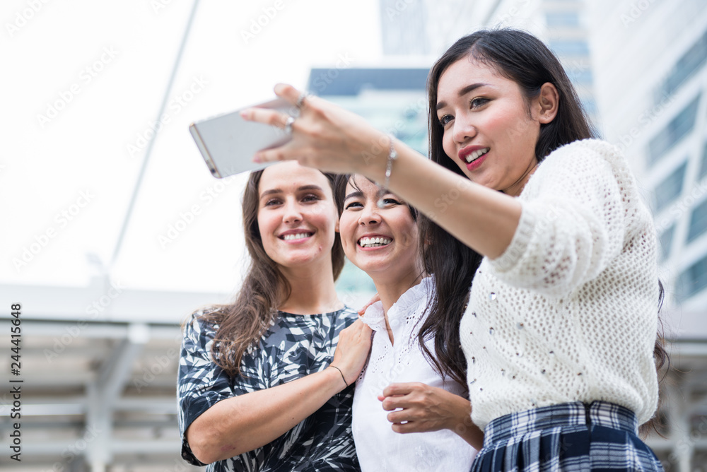 Three young woman making a selfie by smartphone