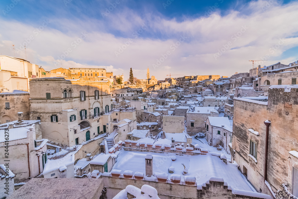 panoramic view of Sassi di Matera and church of Matera 2019 under blue sky with clouds and snow on the house, concept of travel and christmas holiday on snowflakes,capital of europe culture 2019