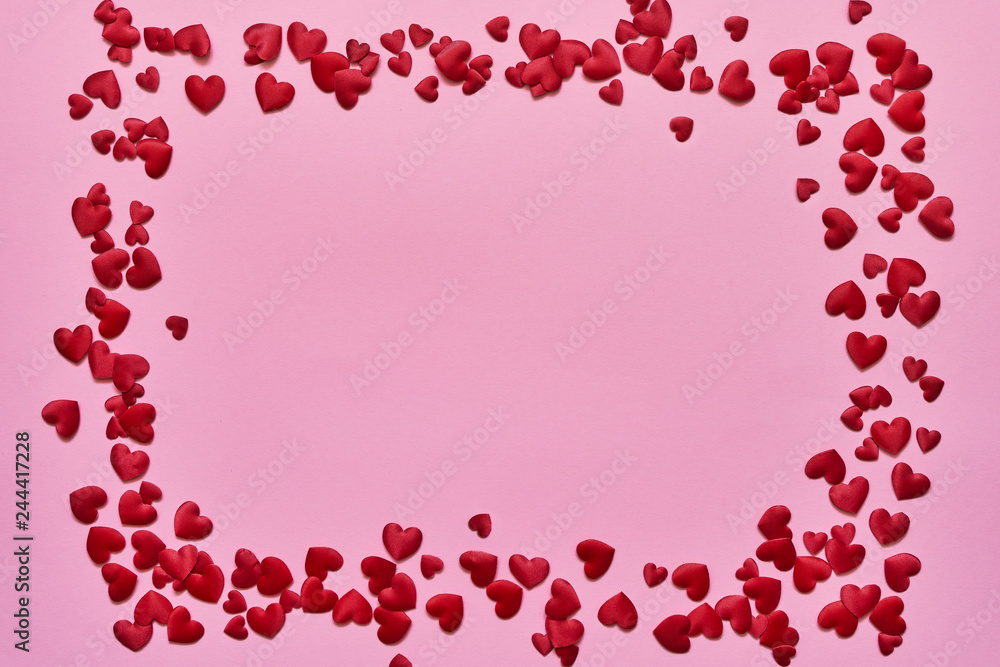 Valentines Day background. Border of red hearts on pink background. Copy space, top view.