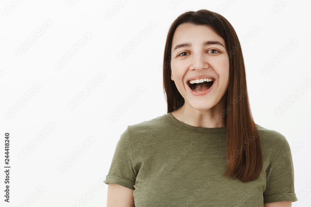 Haha so funny. Portrait of amused and carefree girl having fun laughing out loud with opened mouth looking delighted and enertained at camera watching hilarious tv-show, joking over gray background Haha so funny. Portrait of amused and carefree girl having fun laughing out loud with opened mouth looking delighted and enertained at camera watching hilarious tv-show, joking over gray background