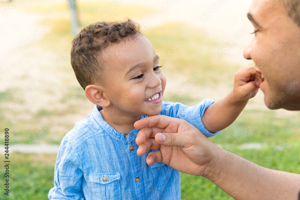 Lovely kid showing teeth to his father. Lovely kid showing teeth to his father.