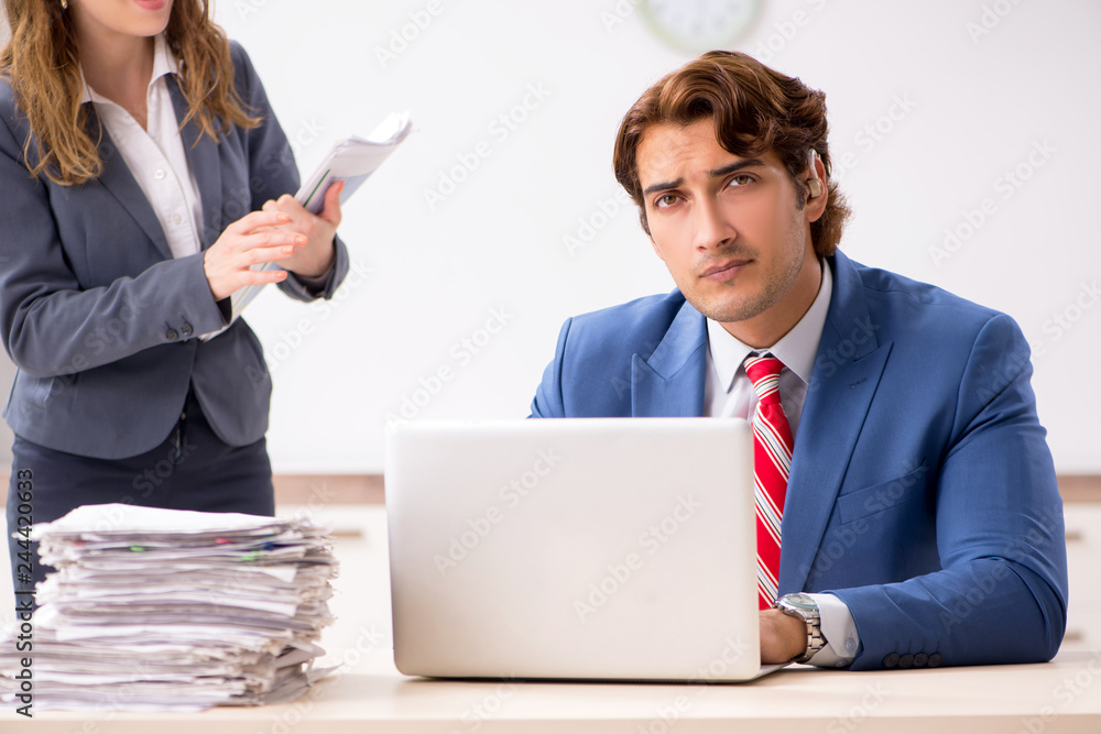 Deaf employee using hearing aid talking to boss Deaf employee using hearing aid talking to boss