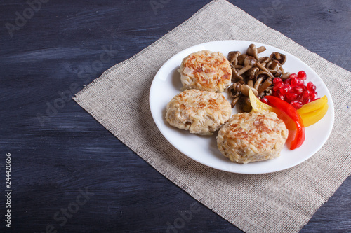 meatballs with rice mushrooms, sweet peppers and pomegranate seeds on black wooden background.