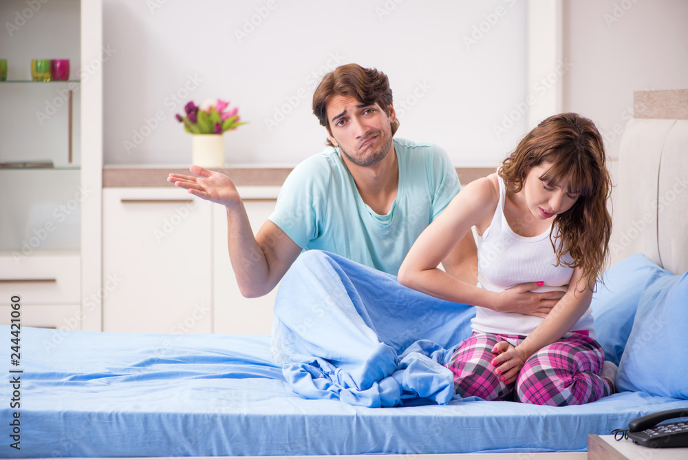 Sick young woman with husband in the bedroom Sick young woman with husband in the bedroom