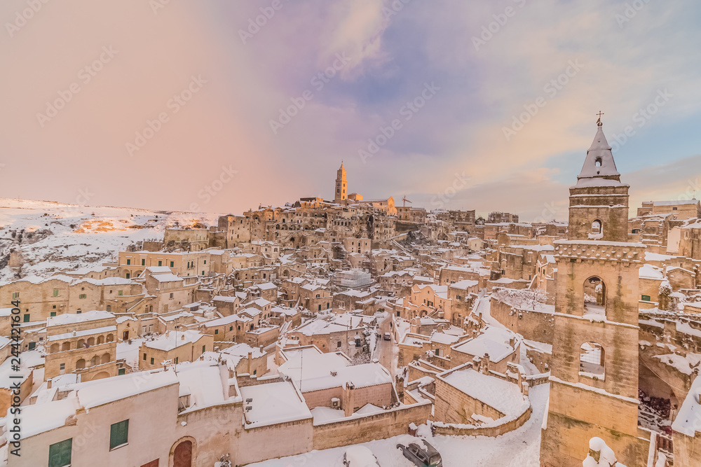 panoramic view of typical stones Sassi di Matera and church of Matera 2019 under blue sky with clouds and snow on the house, concept of travel and christmas holiday ,capital of europe culture 2019