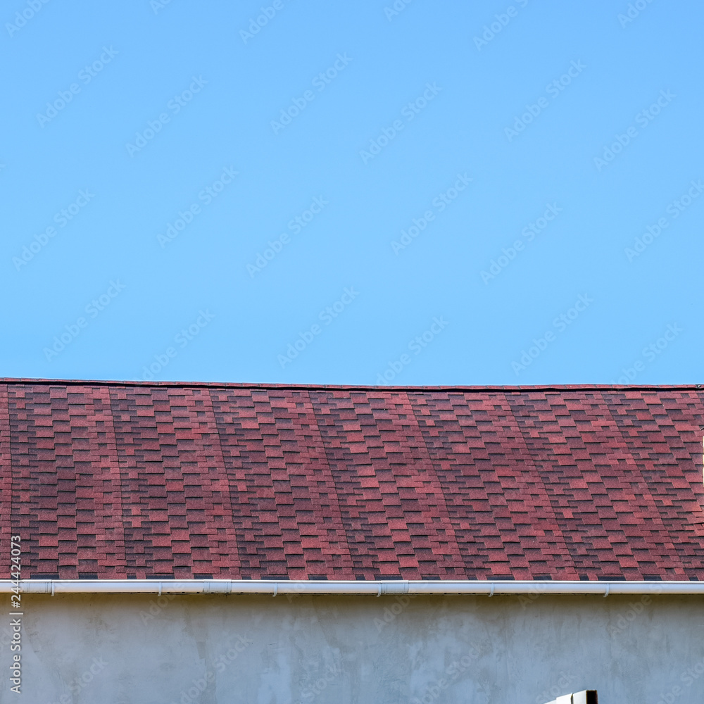 Roof from multi-colored bituminous shingles. Patterned bitumen s