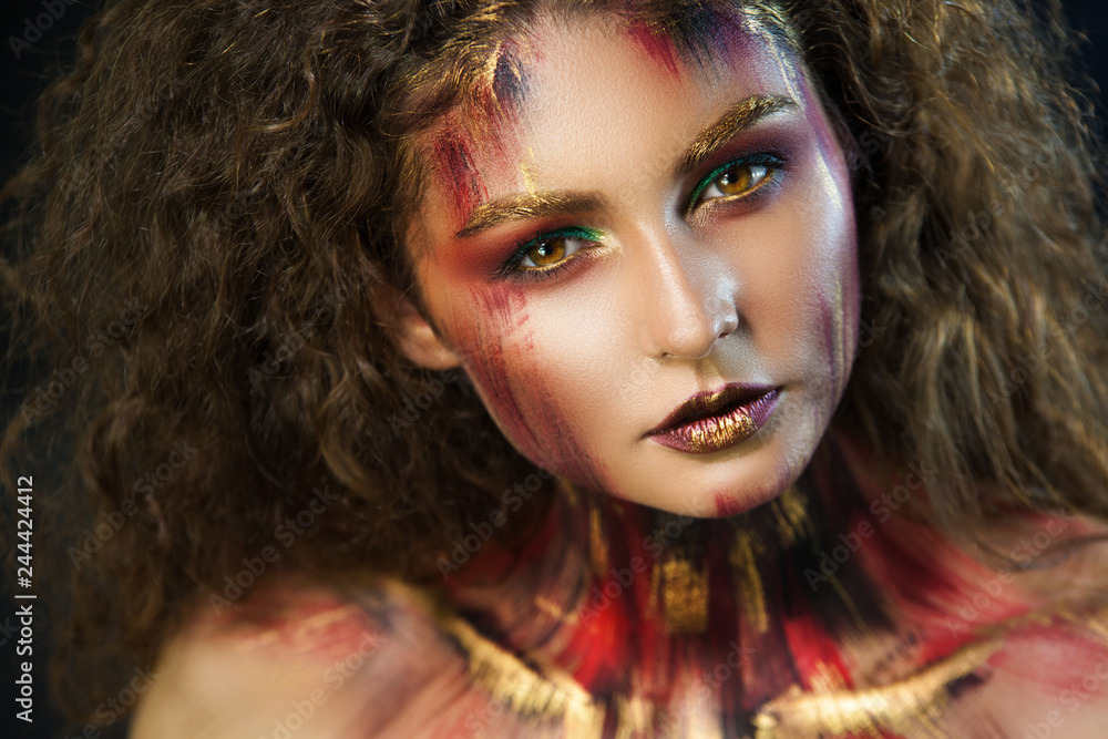 beautiful curly girl in a fire makeup and green shadows under the cloak image created by a make-up artist beautiful curly girl in a fire makeup and green shadows under the cloak image created by a make-up artist