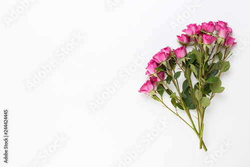 Flowers composition. Frame made of red rose on white wooden background. Flat lay, top view, copy space. © gitusik