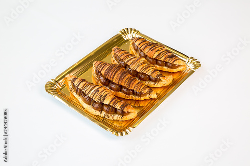 chocolate croissants in a gold tray on white background