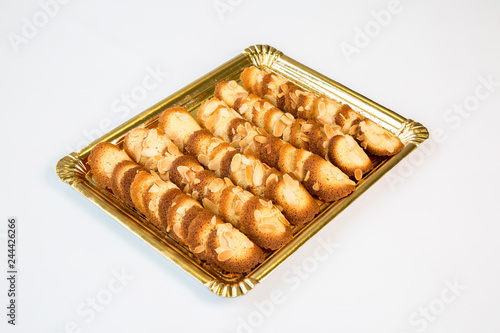 almond cookies in a gold tray on white background