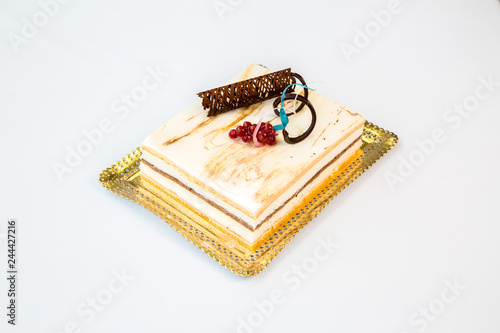 white chocolate cake on a gold tray on white background