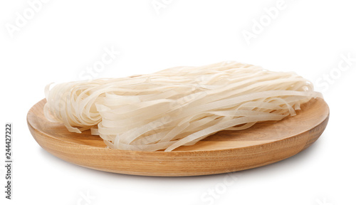 Wooden plate with raw rice noodles on white background