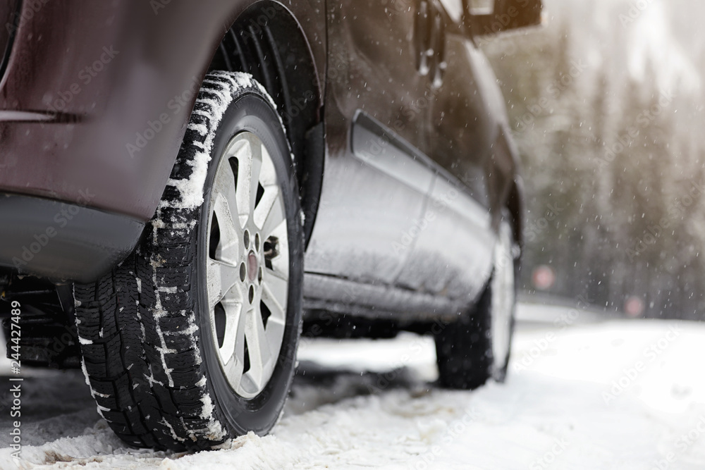 Naklejka premium Wiejska droga z samochodem w śnieżny zimowy dzień
