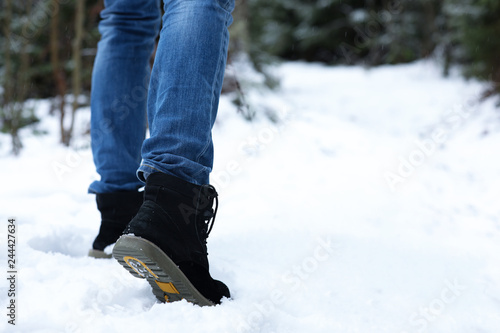 Woman walking outdoors on snowy day, closeup with space for text. Winter vacation