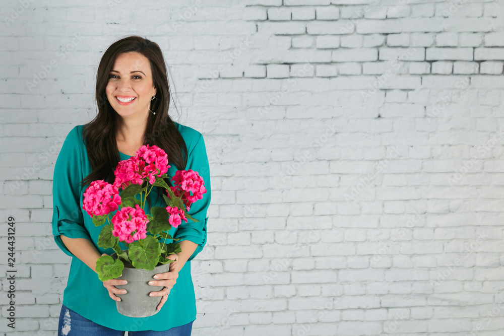 Fototapeta premium Beautiful Hispanic Woman Holding a pot of Pink Spring Flowers