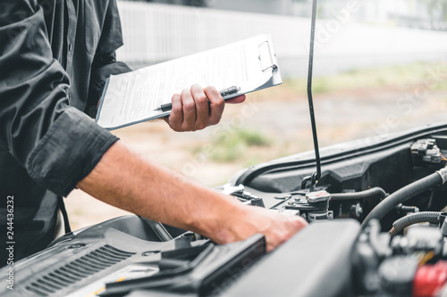 Auto mechanic working in garage Technician holding clipboard and check mechanic Maintenance car check. © joyfotoliakid