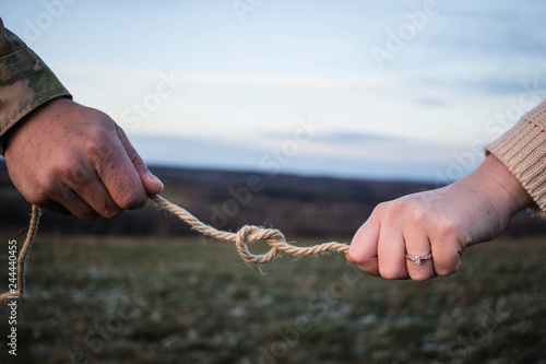 Engaged couple holding a knotted rope