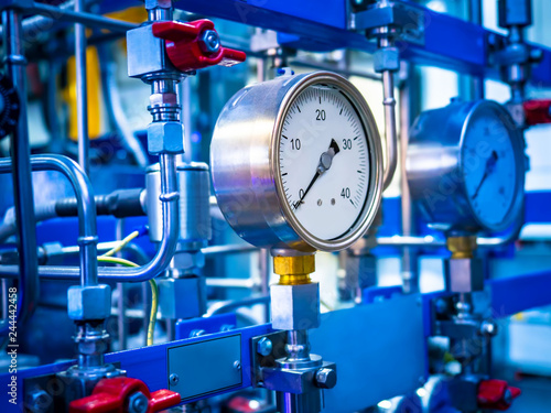 Pressure gauge. Industrial concept. Sensors on the pipes. Red valve on the pipe. Fragment of industrial apparatus.