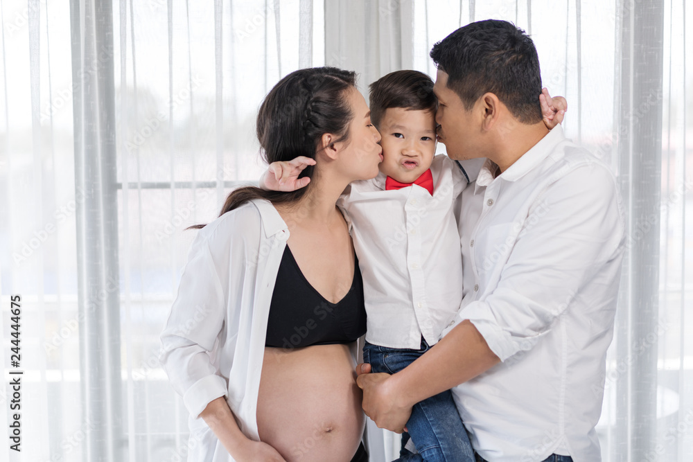 happy family concept, pregnant mother and father kissing boy happy family concept, pregnant mother and father kissing boy