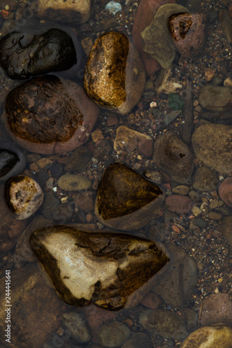 Stones in the river photographed from above / Clear river water and colorful stones/ Photo of stones in the clear river /Background with stones and clear river water