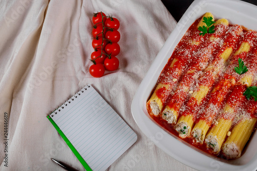 Italian pasta cannelloni with meat and tomato sauce and cheese on table photo