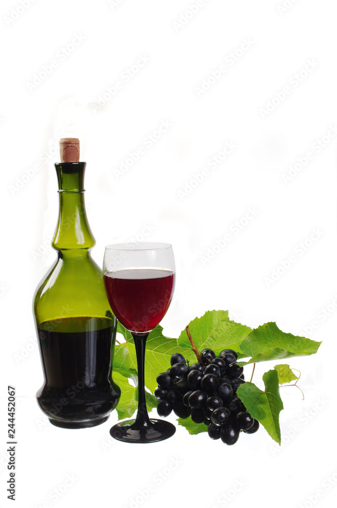 A glass of red wine, a bottle and a bunch of grapes. Isolated on white