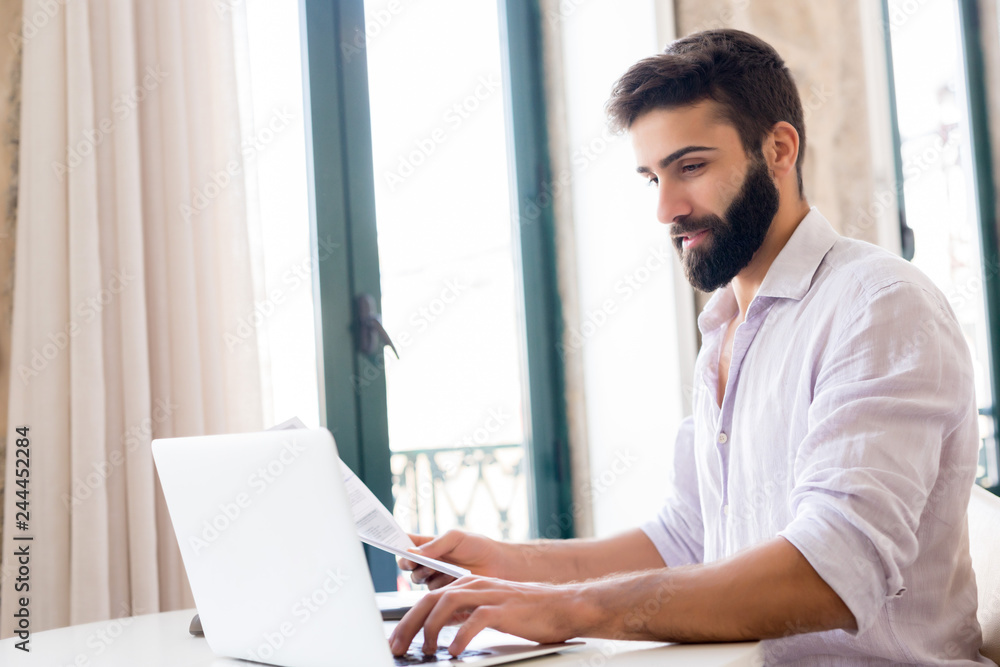 Fototapeta premium Man working on laptop from home